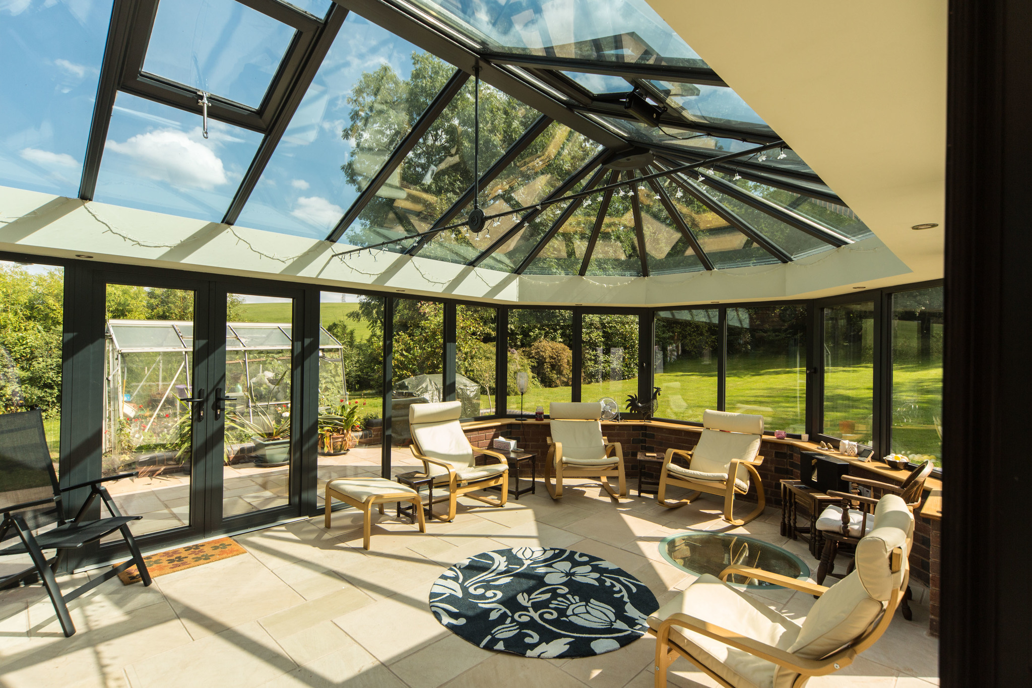 A {large} conservatory with a glass roof offering {stunning views} in Westbury-On Severn.