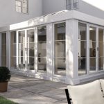 A white conservatory {in} a garden.